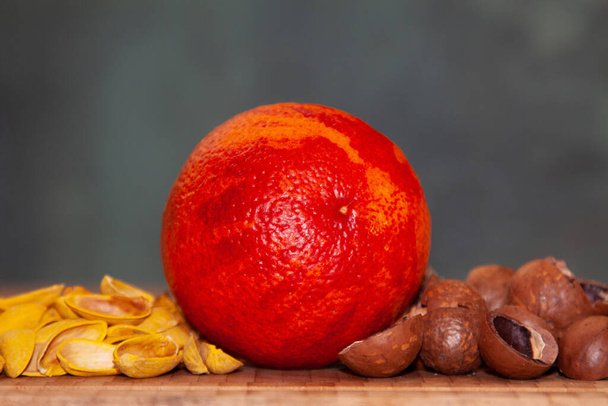 Reddish orange among shells from pistachios and macadamia - Valokuva, kuva