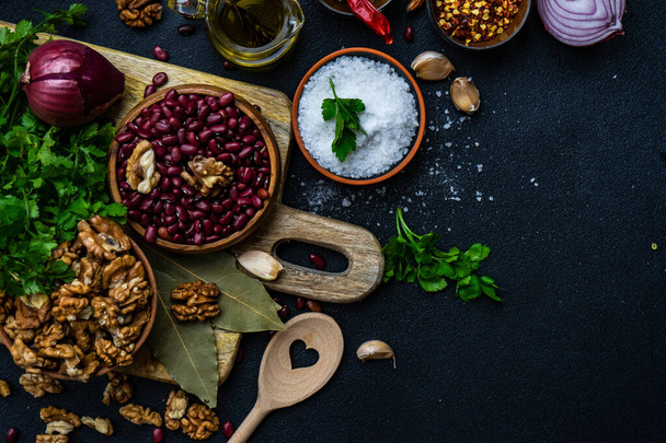 Ingredients for cooking georgian traditional dish lobio with red beans with nuts on rustic background with copy space - 写真・画像