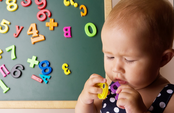 Funny baby girl playing with letters - Foto, imagen