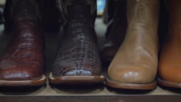 Cowboy laarzen op een plank in de winkel uitgelijnd, close-up. - Video