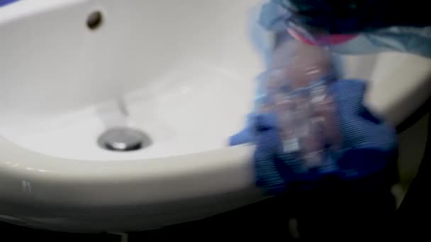 Woman at home cleaning bathroom sink. Coronavirus prevention measures. - Footage, Video