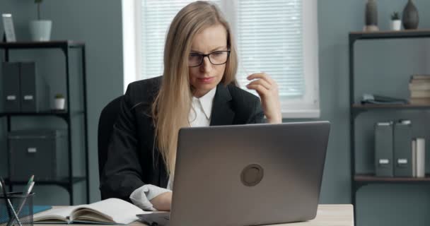 Focused businesswoman sitting at table with laptop - Footage, Video