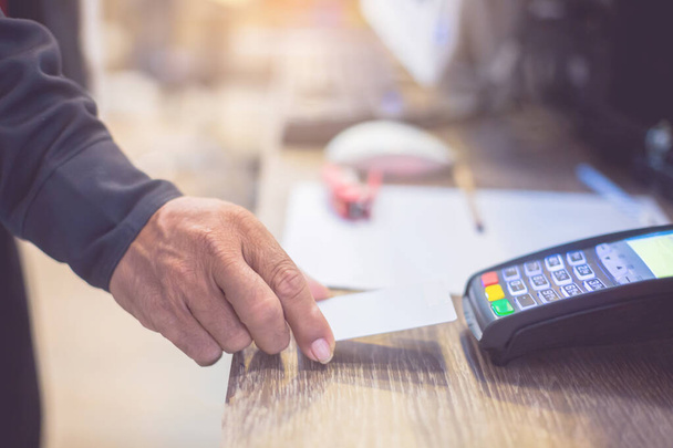 Hand put credit card In slot of credit card reader, credit card payment, buy and sell products & service, the concept of payment without cash, selective focus. - 写真・画像