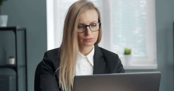 Close up of mature woman in eyeglasses working on laptop - Felvétel, videó