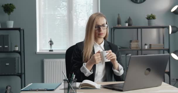 Mature woman drinking coffee and working on computer - Materiaali, video