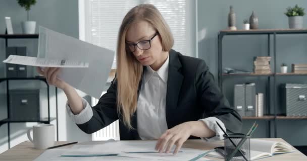 Confused businesswoman working with paper documents - Кадры, видео