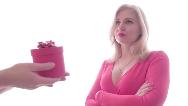 Overbearing blonde woman in a red dress with a plunging neckline received a gift from the men's hands, opens the gift and throw it out with unsatisfactory face. Bad manner concept - Footage, Video
