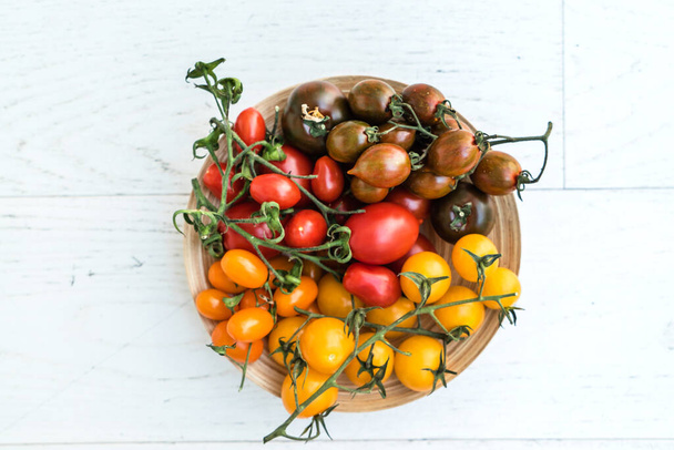 colorful tomatoes on the wooden background - Фото, зображення