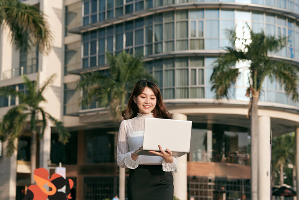 Portrait de mignonne jeune femme d'affaires en plein air avec café et ordinateur portable - Photo, image