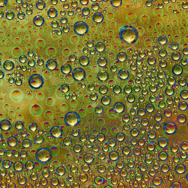 Különböző átmérőjű gömbök narancssárga, sárga és arany színek és zöld tükröződések véletlenszerűen található egy arany háttér. Absztrakt fantázia.  - Fotó, kép