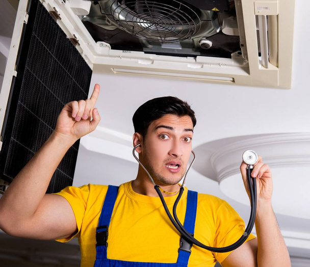 Reparador reparando la unidad de aire acondicionado del techo - Foto, Imagen