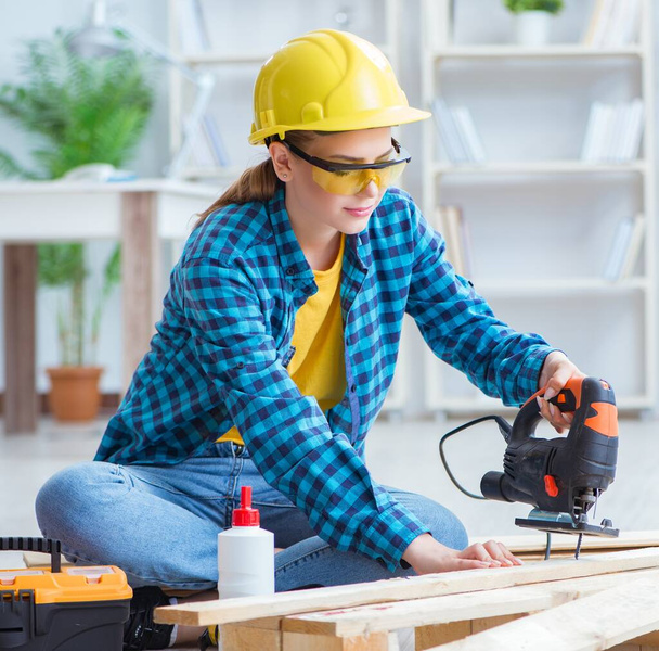 Reparador feminino carpinteiro corte juntando tábuas de madeira fazendo r
 - Foto, Imagem