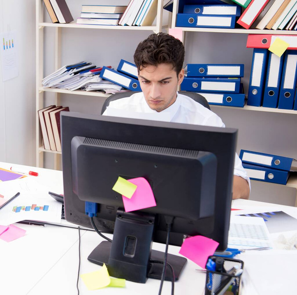 Podnikatel pracující v kanceláři s hromadami knih a papírů - Fotografie, Obrázek