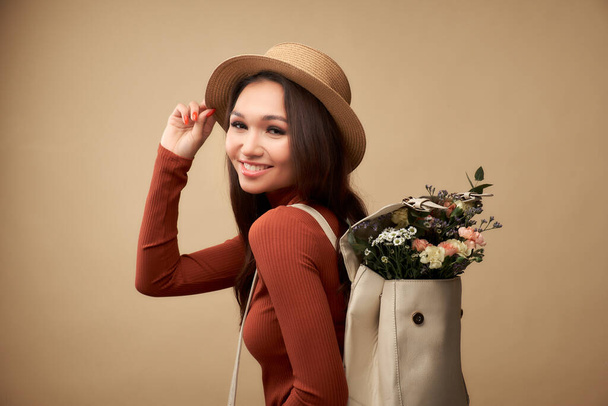 Backpack with flowers. Creative fashion portrait of beautiful y - Foto, imagen