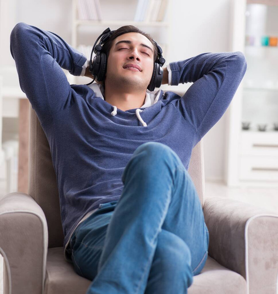 Young man listening to music at home - 写真・画像