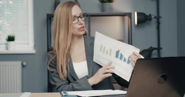 Woman showing financial report during video chat - Video