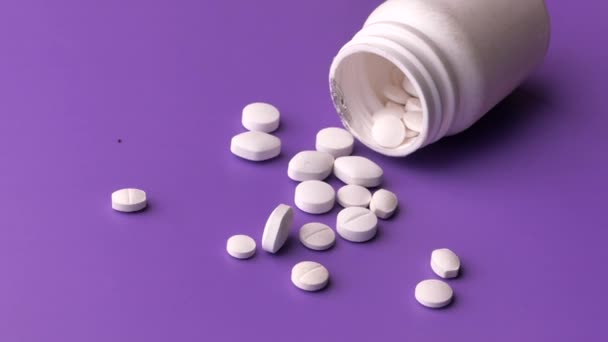 közeli-ból fehér tabletták ömlött egy fehér háttér  - Felvétel, videó