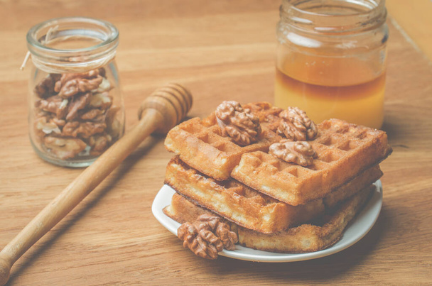 Wafels. Zelfgebakken gebak, wafels en walnoot met honing op een houten ondergrond. - Foto, afbeelding