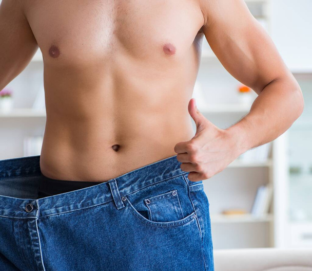 Uomo in pantaloni oversize nel concetto di perdita di peso - Foto, immagini