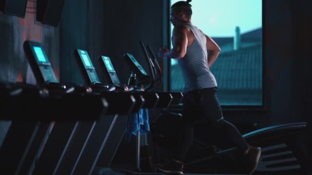 handsome active man running on treadmill in modern gym - Felvétel, videó