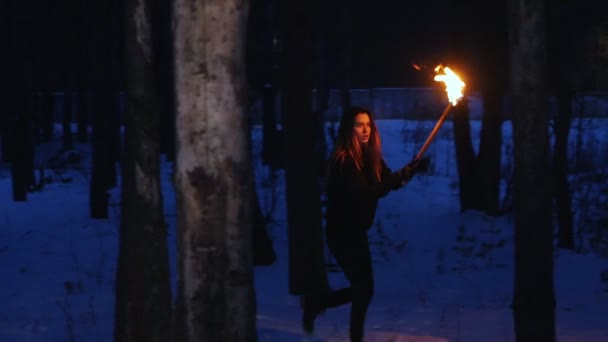 Young scared woman with torch walking outdoors - Video