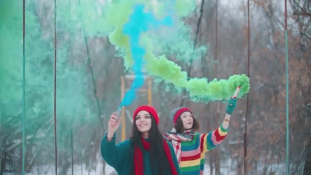 Dos mujeres jóvenes divirtiéndose con bombas de humo al aire libre
 - Metraje, vídeo