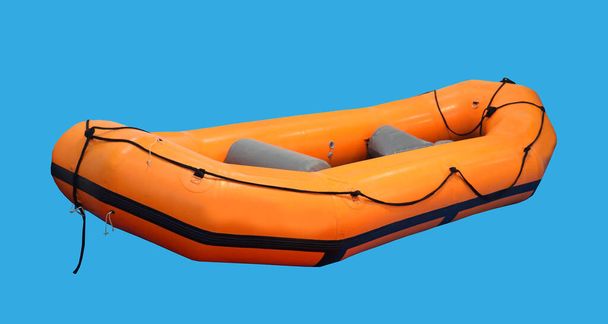 Orange rubber inflatable boat isolated on blue background - Foto, Imagen