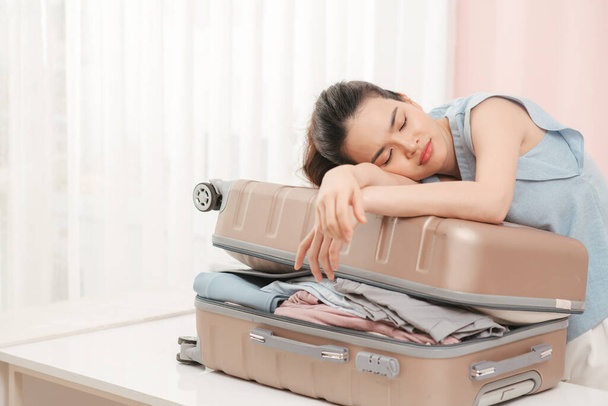 Woman prepare travel suitcase at home. Excited woman trying to close full suitcase. - Φωτογραφία, εικόνα