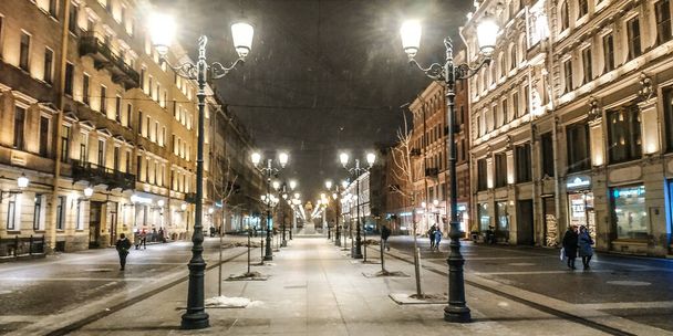 pedestrian street among lanterns during late night snowfall - Foto, Imagem