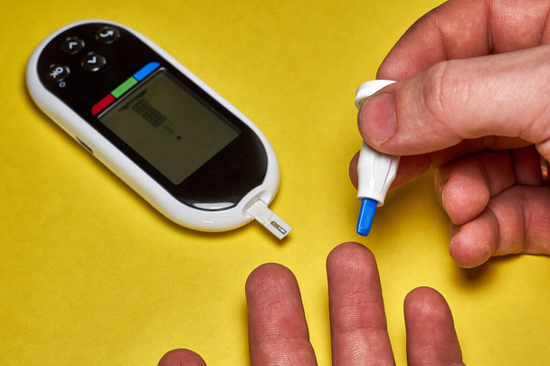 Diabetik kontroluje hladinu cukru v krvi. Detailní muž ruce self-testovány s Lancet a glukometrem doma - Fotografie, Obrázek