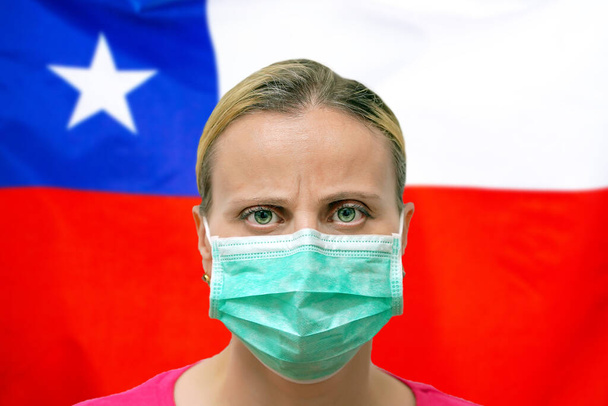 Maskovaná žena se dívá do kamery na vlajce Chile pozadí. Koncept pozornosti na celosvětové rozšíření koronaviru po celém světě. Koronavirus, virus v Chile. - Fotografie, Obrázek