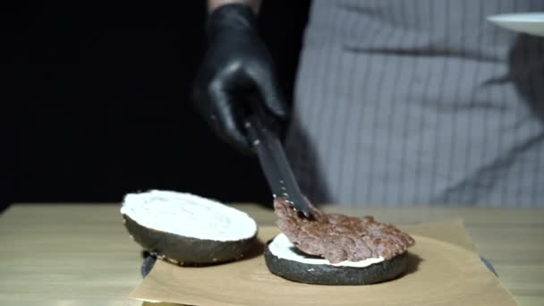 Chef preparing the burger. Close up hands of man laying out meat for hamburger - Záběry, video