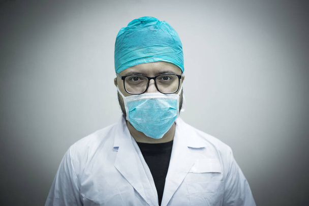 Portret van een blanke dokter staand en kijkend naar de camera - Foto, afbeelding