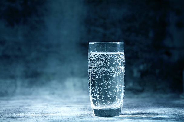 Copo de água com gás sobre fundo cinzento
 - Foto, Imagem