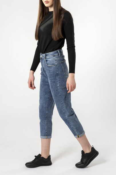 girl in jeans shows off jeans on white background close up, blue jeans - Zdjęcie, obraz