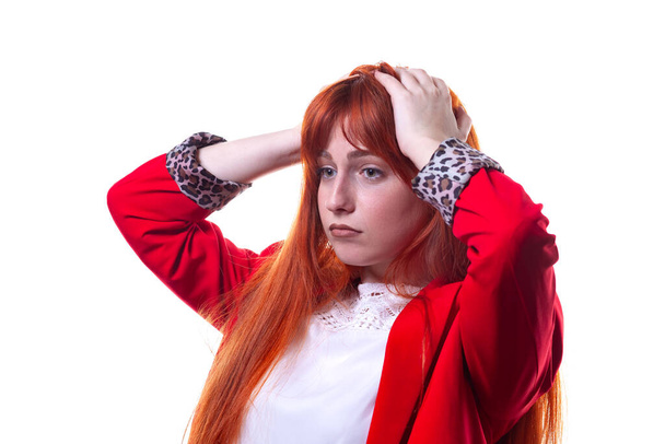 Krásná zmatená mladá žena v červené bundě myšlení a tření vlasů. Model. - Fotografie, Obrázek