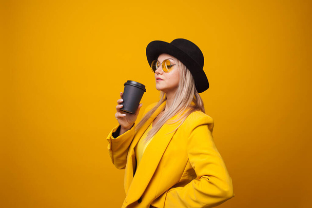 Stylish trendy young woman in bright clothes on a yellow background. Cool blonde - Zdjęcie, obraz