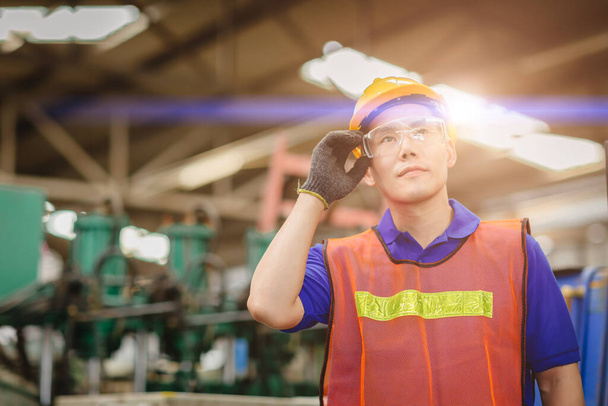 Portret inteligentnego inżyniera Azjatycki chiński szczęśliwy pracownik pracy przystojny model w przemyśle ciężkim tła.hand na okulary ochronne. - Zdjęcie, obraz