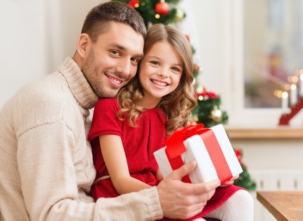Smiling father and daughter holding gift box - Фото, зображення