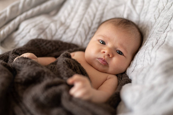 Baby girl wrapped in blanket, lying in bed - Valokuva, kuva