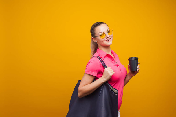 Business positive girl in casual style hurries on business and drinks coffee to take away. Coffee break - Φωτογραφία, εικόνα