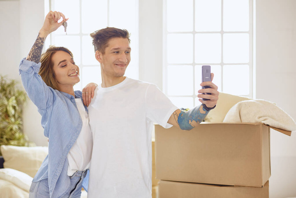 Happy smiling young couple showing a pair of keys of their new house - Foto, Imagem