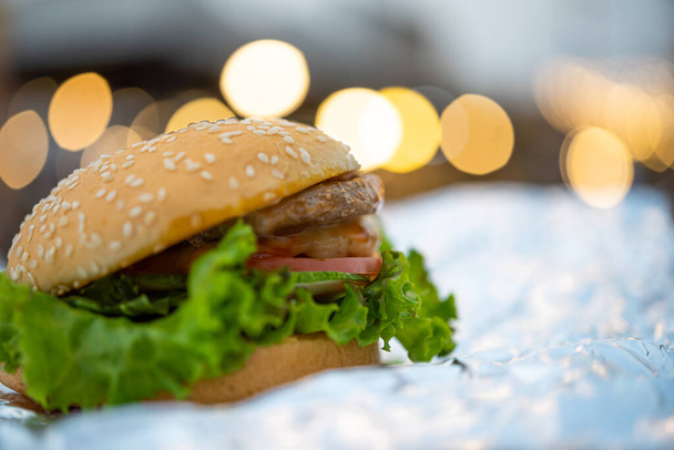 Hamburger is een fastfood bereiding van broodjes, vlees, kaas en groente in fastfood restaurant, ongezond voedsel of vet concept - Foto, afbeelding