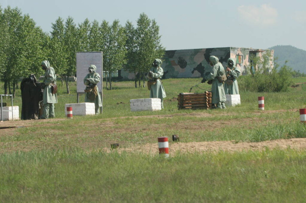 El campo de entrenamiento de tanques en Siberia Oriental. Los ejercicios militares de la brigada de tanques en una situación cercana a la batalla en Rusia. Ataque de gas
. - Foto, imagen