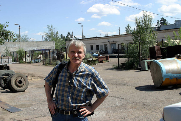 Mann mittleren Alters im Hof einer Autowerkstatt - Foto, Bild