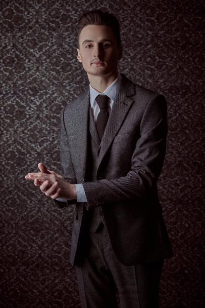 Porträt eines gutaussehenden Mannes im eleganten klassischen Anzug und Krawatte auf Vintage-Hintergrund. Geschäftsstil. Männermode. - Foto, Bild