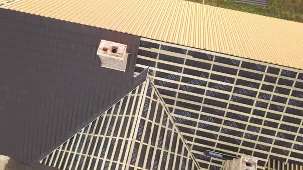Vue aérienne de la maison inachevée avec structure de toit en bois recouvert de plaques de métal en construction. - Séquence, vidéo