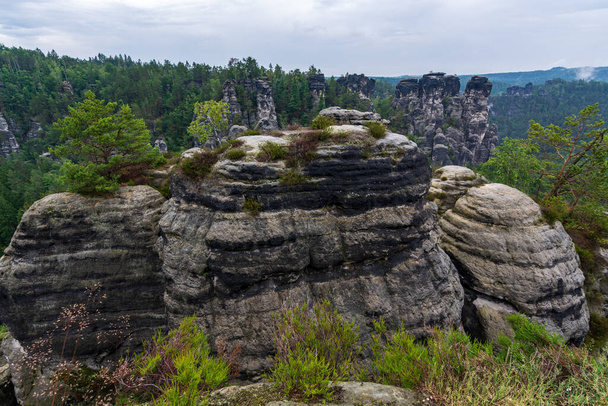 Lots of rocks in Saxon Switzerland near Dresden with clouds and fog - Foto, Imagen