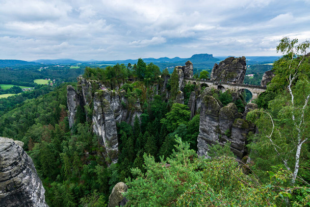 Die berühmte Basteibrücke in der Sächsischen Schweiz an einem bewölkten Tag - Foto, Bild