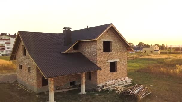 Aerial view of unfinished house with wooden roof structure covered with metal tile sheets under construction. - Footage, Video